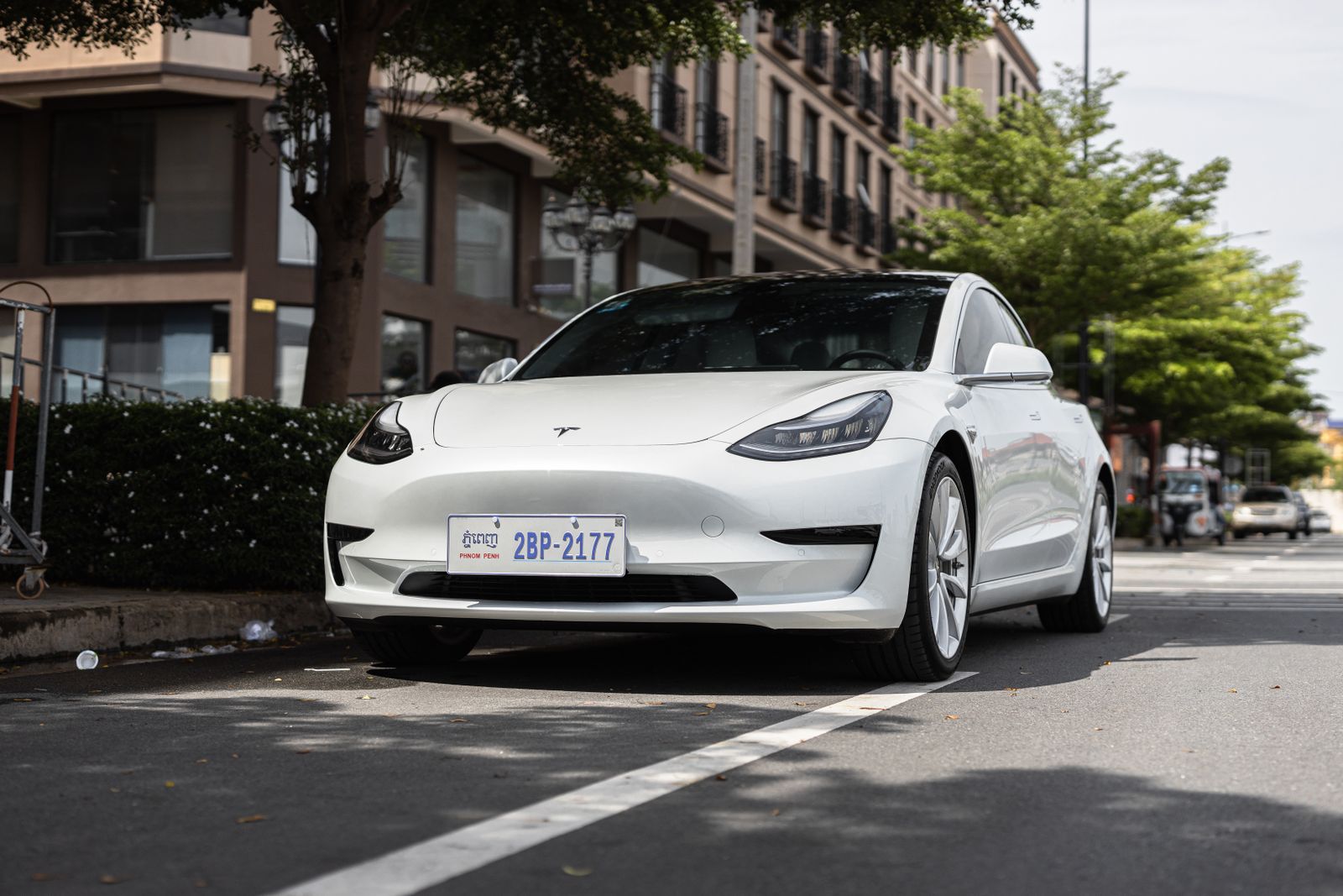 A white Tesla Model 3 parked on a street