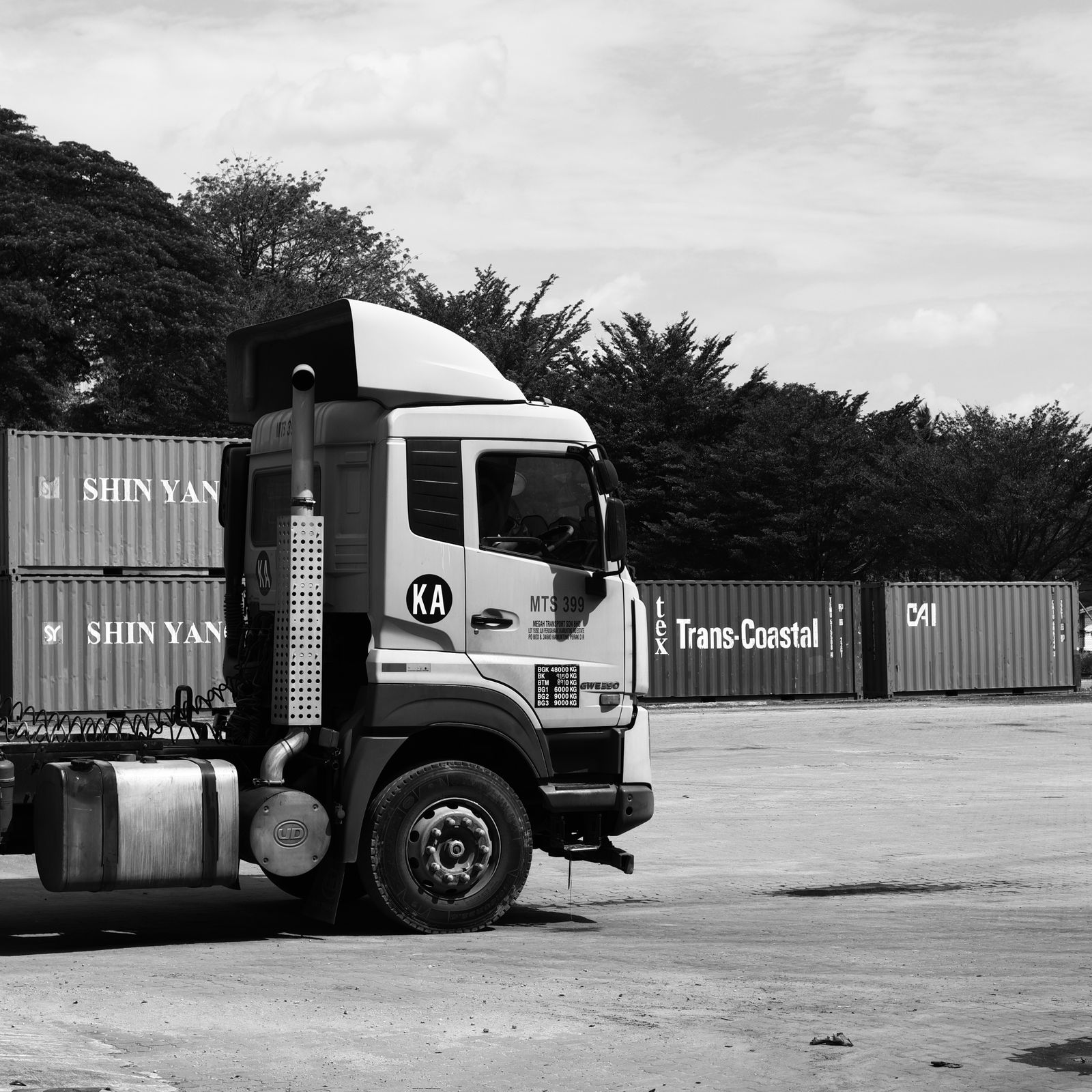 A semi truck hauling freight at a shipping yard