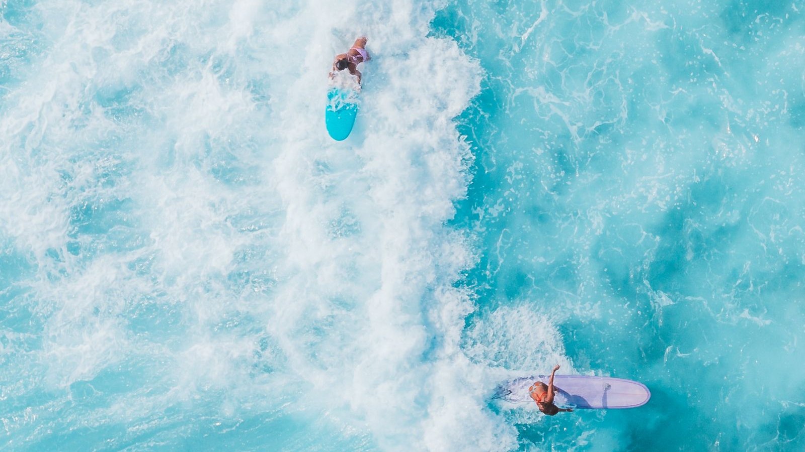 Surfer riding a wave in clear turquoise water
